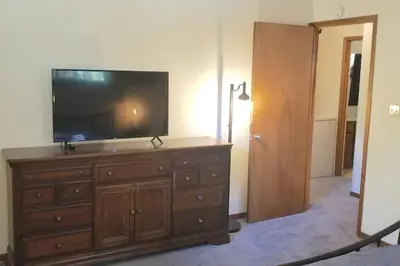 a room with a dresser with a flat screen tv on it at Mountain Life On Deck in Arnold