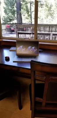 a laptop computer sitting on a desk next to a window at Mountain Life On Deck in Arnold