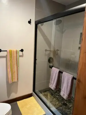 a bathroom with a glass shower stall with towels at Cabin in the Woods in Tahoe Vista