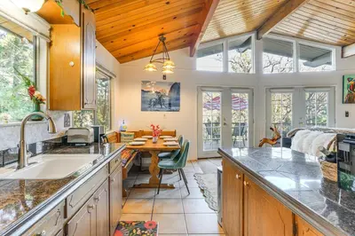 a kitchen with a sink and a table in a room at Enchanted Woodland Cabin Near Yosemite with Fire Pit in Groveland