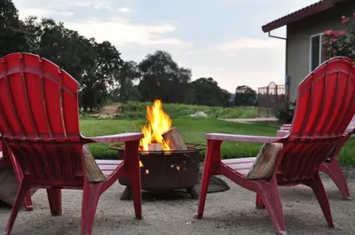 two red chairs sitting next to a fire pit at Balcony Suite 2 Fraser Family Vineyard Stay in Amador in Plymouth