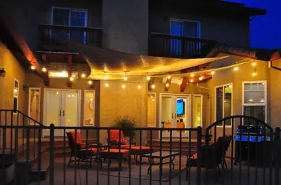 a patio with a table and chairs and lights at Balcony Suite 2 Fraser Family Vineyard Stay in Amador in Plymouth