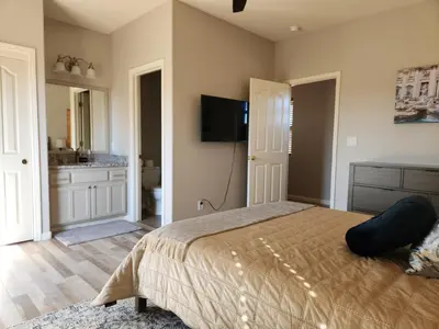 a bedroom with a bed and a tv on the wall at Balcony Suite 2 Fraser Family Vineyard Stay in Amador in Plymouth