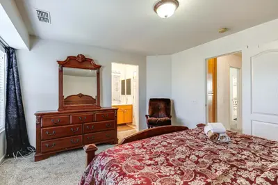 a bedroom with a bed with a dresser and a mirror at Spacious Turlock Home about 1 Mi to University! in Turlock