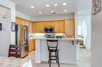 a kitchen with wooden cabinets and stainless steel appliances at Spacious Turlock Home about 1 Mi to University! in Turlock