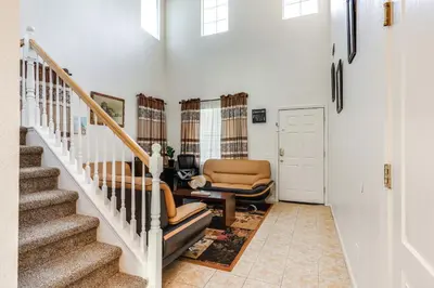 a living room with a stairway with two chairs at Spacious Turlock Home about 1 Mi to University! in Turlock