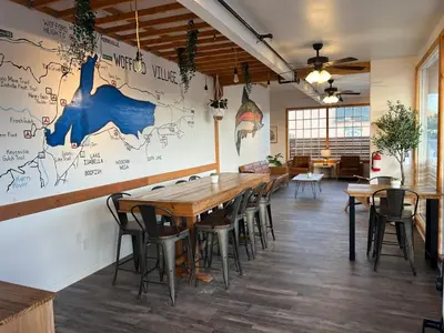 a restaurant with wooden tables and chairs and a map on the wall at Wofford Village Studios in Wofford Heights