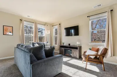 a living room with a couch and a chair at MidTown Hideaway Fire Pit and King Beds in Reno