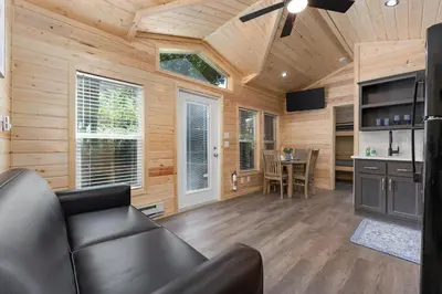 a living room with a leather couch in a log cabin at Brand New Cabin in Kernville