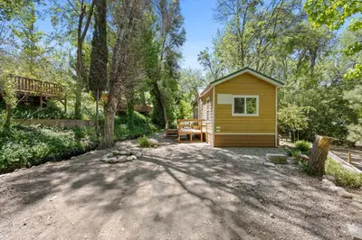 a small cabin in the woods with a patio at Brand New Cabin in Kernville