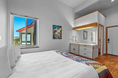 a white bedroom with a large bed and a sink at Sierra Cabin Condo – Sun Meadows 1 BedroomLoft condo in Kirkwood