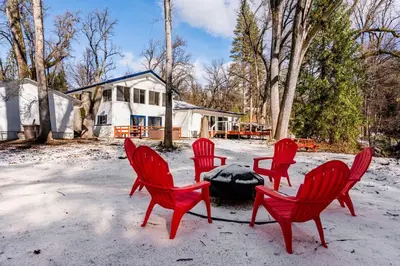 four red chairs around a fire pit in the snow at Modern LakeHouse Sleeps 20 Hot Tub/Games/Fire Pit in Oakhurst