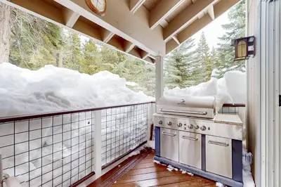 a kitchen with a stove on a balcony with snow at Blue Skies & Bay Bliss in Carnelian Bay