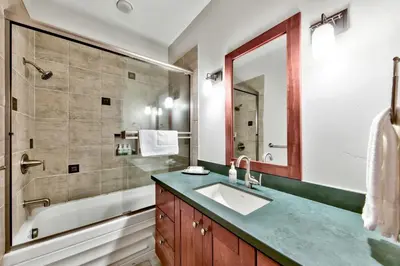 a bathroom with a sink and a tub and a mirror at Sierra Shores Five - Lakefront Comfort in South Lake Tahoe