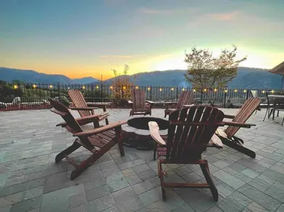a group of chairs and a table with a sunset in the background at Stargazing Retreat: fire pit/hot tub near Yosemite in Ahwahnee