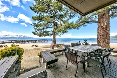 a wooden deck with a table and chairs on the beach at Lakeland Village 619 Lovely Family Lakefront in South Lake Tahoe