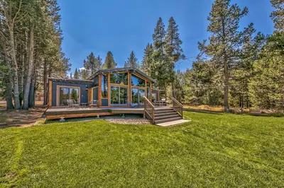 a house in a field of grass with a porch at Duckhook at Tahoe in South Lake Tahoe