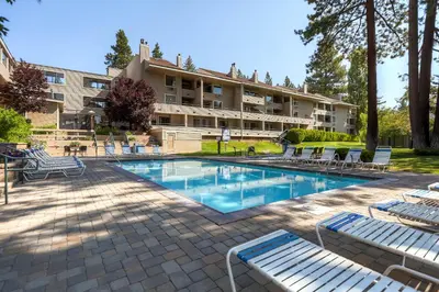 a hotel with a swimming pool with lounge chairs at Lakeland Village 410 in South Lake Tahoe