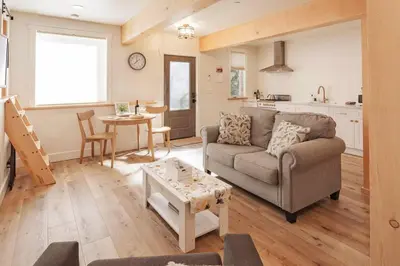 a living room with a couch and a table at Timberwood Cottage in Downtown Twain Harte in Twain Harte