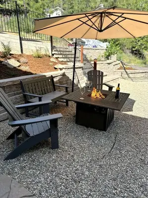 a picnic table with an umbrella and two benches at Timberwood Cottage in Downtown Twain Harte in Twain Harte