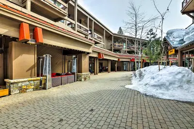 an empty street with a pile of snow in front of a building at Northstar Resort Condo with Hot Tub, Shuttle Access! in Truckee