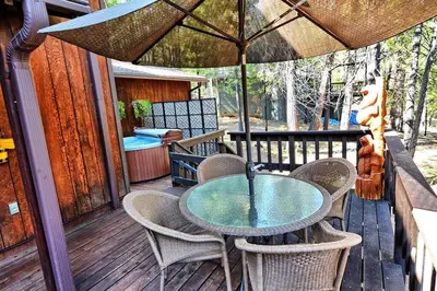 a table and chairs on a deck with an umbrella at *Pinecone Hollow*Hot Tub & Game Room, Families in Arnold