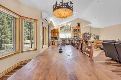 a large dining room and kitchen with a large wooden table at 1603 Bel Aire Circle home in South Lake Tahoe
