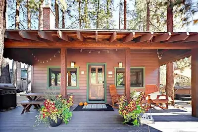 a small wooden house with a porch and a picnic table at 3988 Manzanita Avenue cabin in South Lake Tahoe