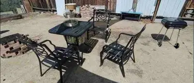 a table and two chairs and a grill in a yard at Petite Guesthouse with Kitchenette and Private Bathroom in Lake Isabella