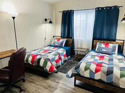 a bedroom with two beds and a desk and a chair at Sweet Holiday in Antelope