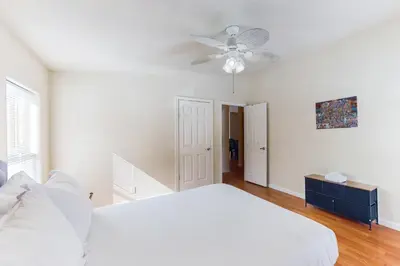 a white bedroom with a bed and a ceiling fan at Zerenity Lookout East in Oakhurst