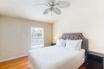 a bedroom with a white bed with a ceiling fan at Zerenity Lookout East in Oakhurst