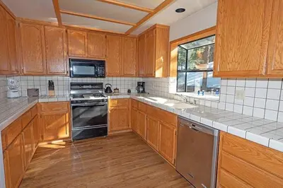a kitchen with wooden cabinets and stainless steel appliances at 2293 Marshall Trail home in South Lake Tahoe