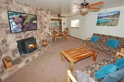 a living room with a stone wall with a fireplace at 1987 Cherokee St, home in South Lake Tahoe