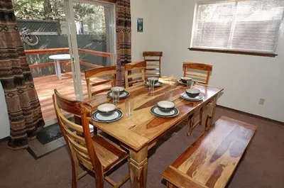 a wooden dining room table with wooden chairs and a tableastery at 1987 Cherokee St, home in South Lake Tahoe