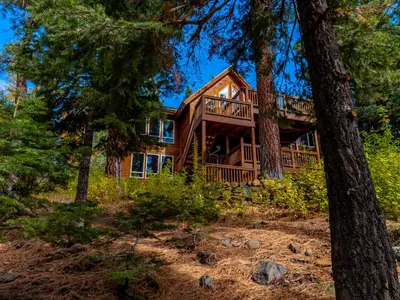 a log cabin in the woods with trees at Canterbury Lodge in Kings Beach