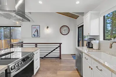 a kitchen with white cabinets and a clock on the wall at Fun & Air Conditioned Lake Tahoe 3 BR/2.5 BA Home in Incline Village