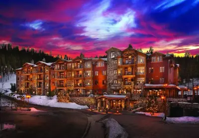 a large resort building with a sunset in the background at Hyatt Vacation Club at Northstar Lodge in Truckee