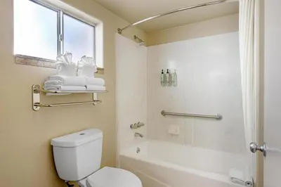a bathroom with a toilet and a tub and a sink at Best Western Frontier Motel in Lone Pine