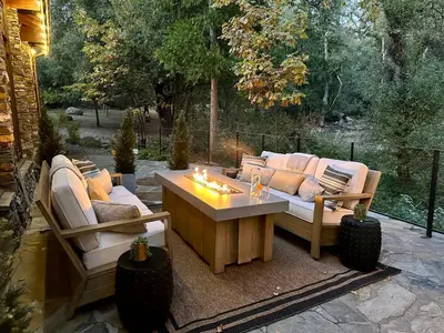 a patio with a couch and a table with candles at Luxury Nature Getaway Stone House by Casa Oso in Mariposa