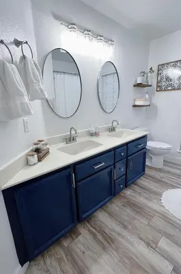 a bathroom with a blue sink and two mirrors at Serene Modern Family Getaway Near Midtown Downtown and Folsom Lake in Elk Grove