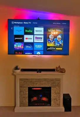 a flat screen tv on a wall above a fireplace at Yosemite's Scenic Hideaway in Midpines