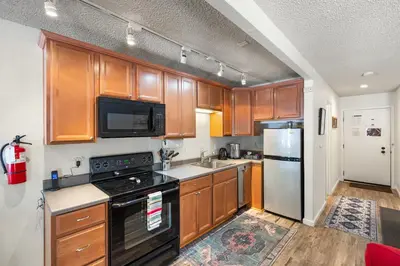 a kitchen with wooden cabinets and stainless steel appliances at Private/Cozy Kings Beach Retreat in Tahoe Vista