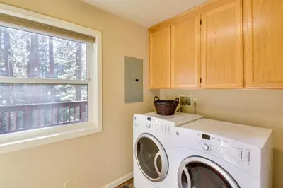 a washing machine in a laundry room with a window at Gas Grill and Pool Table Cabin Near Calaveras Park! in Arnold