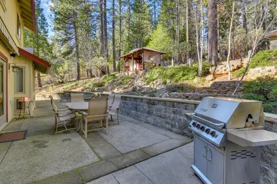 a patio with a stove and a table and chairs at Gas Grill and Pool Table Cabin Near Calaveras Park! in Arnold