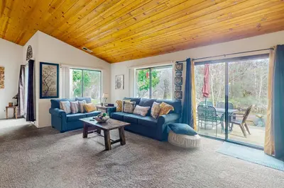 a living room with blue couches and a table at Yard and Patio Quiet and Well-Stocked Riverside Home in Three Rivers