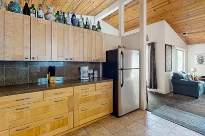 a kitchen with wooden cabinets and a refrigerator at Yard and Patio Quiet and Well-Stocked Riverside Home in Three Rivers
