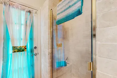 a bathroom with a shower with a blue curtain at Yard and Patio Quiet and Well-Stocked Riverside Home in Three Rivers