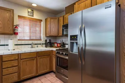 a stainless steel refrigerator in a kitchen with wooden cabinets at Upper Cascades in Yosemite West
