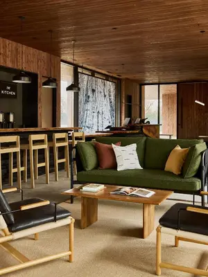 a living room with a green couch and a bar at AutoCamp Sequoia in Three Rivers